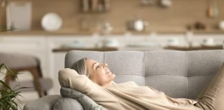 Casa fresca senza aria condizionata: trucchi efficaci donna relax divano