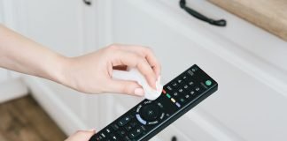 Addio telecomandi e tastiere appiccicose: ecco i rimedi più efficaci Donna pulire telecomando