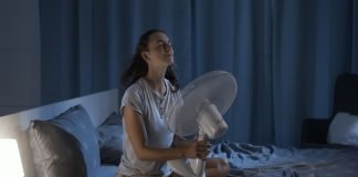 Come funziona il trucco del lenzuolo per dormire con il caldo? Donna letto caldo ventilatore