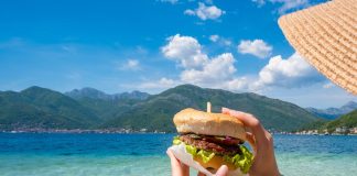 Spiaggia privata o libera, la legge sui cibi “vietati” non cambia Ragazza mangia panino spiaggia