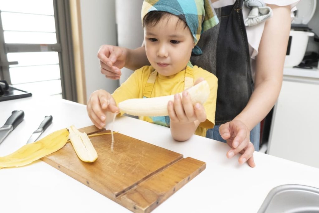 Bambino toglie fili dalla banana